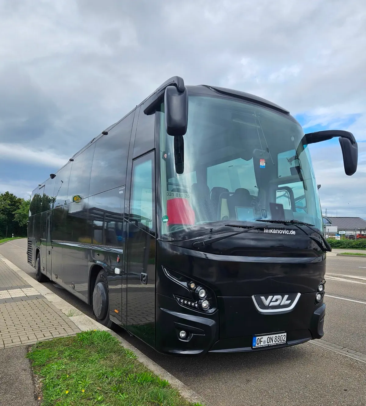 Schwarzer VDL Futura Reisebus mit Offenbacher Kennzeichen am Straßenrand
